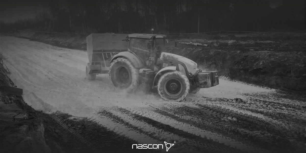 Osuszanie gruntu wapnem . Traktor z siewnikiem dozujący materiał osuszający.