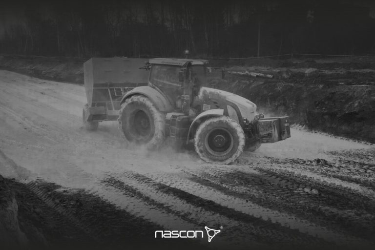 Osuszanie gruntu wapnem . Traktor z siewnikiem dozujący materiał osuszający.